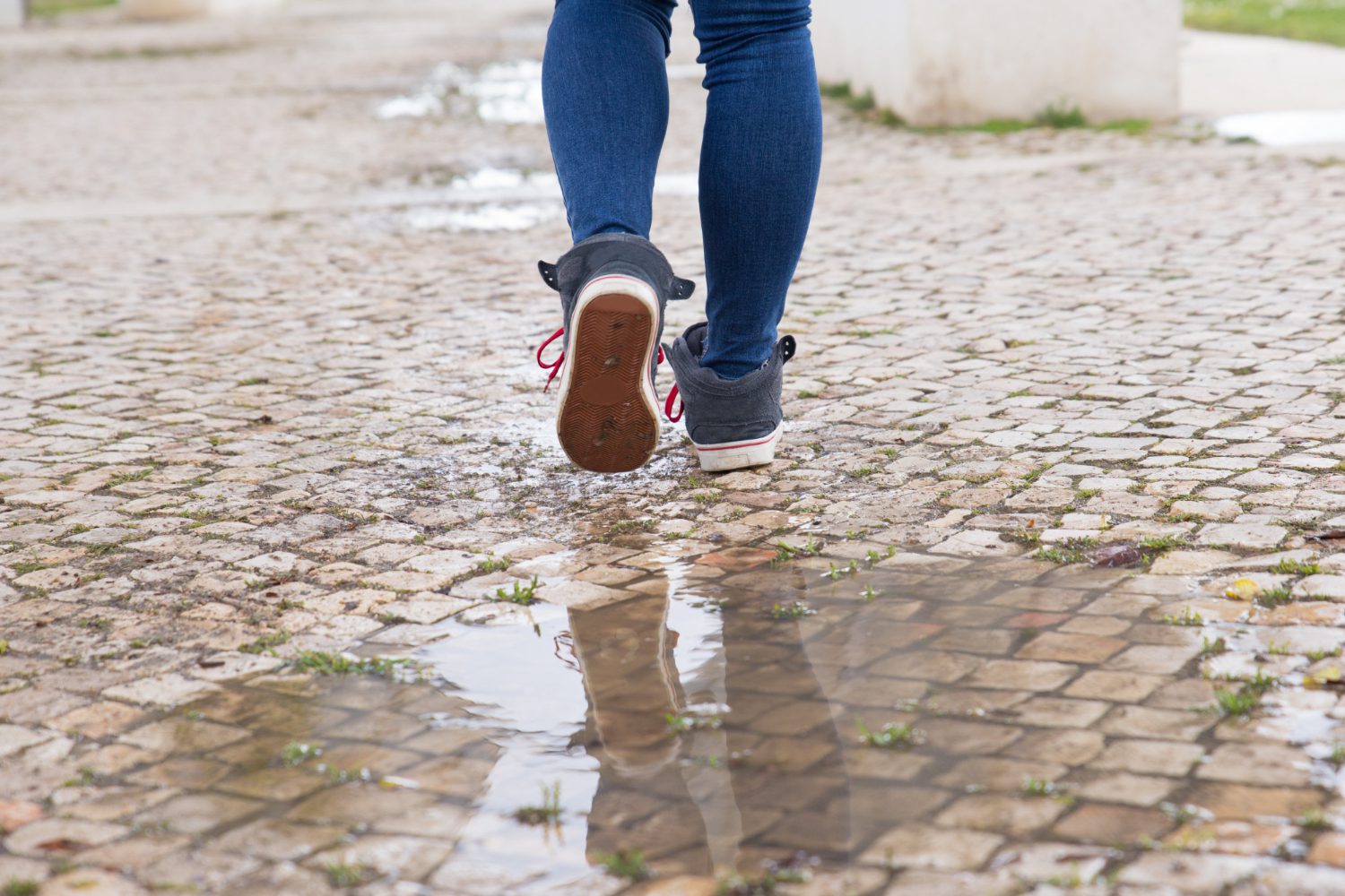 close-up-unrecognizable-woman-walking-stone-pathway